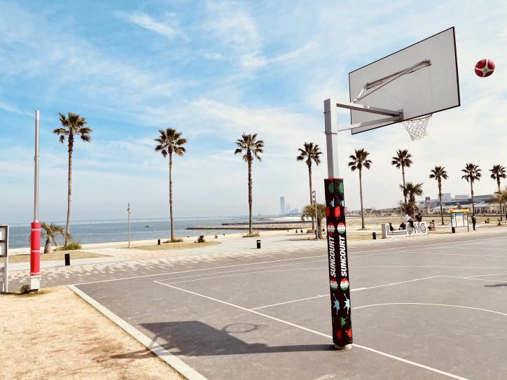 <font color='blue' size='2'>Right next to the parking lot is our meeting spot, “SUNCOURT” for 3 X 3 basketball, and shiny Osaka bay with blue sky reflection!</font>